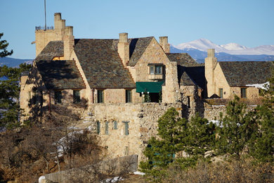 Example of a huge mountain style beige three-story stone exterior home design in Denver with a shingle roof