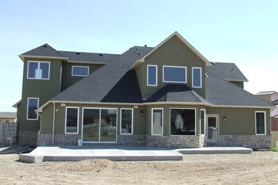 Mid-sized transitional green three-story stucco house exterior idea in Denver with a hip roof and a shingle roof