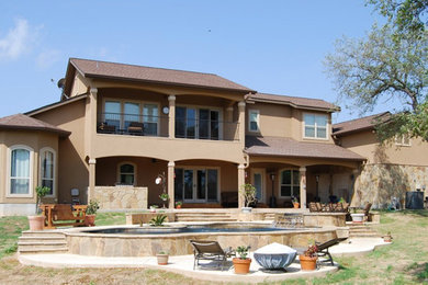 Modelo de fachada de casa beige tradicional grande de dos plantas con revestimientos combinados, tejado a dos aguas y tejado de teja de madera