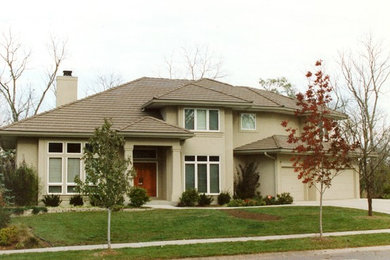 Example of a mid-sized classic beige two-story stucco house exterior design in Kansas City with a hip roof and a shingle roof