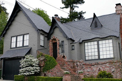 Diseño de fachada de casa gris clásica de tamaño medio de dos plantas con revestimiento de estuco, tejado a dos aguas y tejado de teja de madera