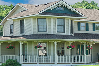 Cette image montre une façade de maison beige traditionnelle en bois de taille moyenne et à un étage.