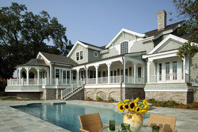 Ejemplo de fachada blanca clásica grande de dos plantas con revestimientos combinados y tejado a dos aguas