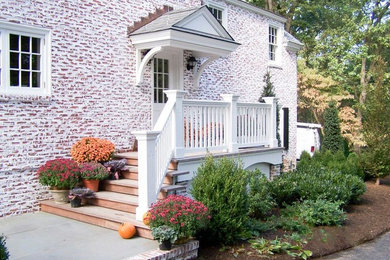 Diseño de fachada de casa multicolor clásica grande de dos plantas con revestimiento de ladrillo y tejado de teja de madera