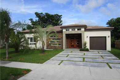 Example of a mid-sized trendy beige one-story stucco exterior home design in Miami