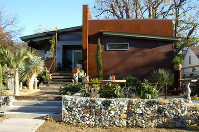 Example of a mid-sized minimalist brown one-story metal exterior home design in Dallas with a shed roof