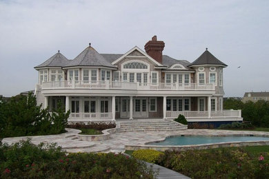 Esempio della facciata di una casa ampia beige classica a due piani con rivestimento in legno e tetto a capanna