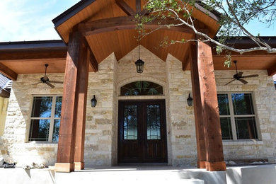 Diseño de fachada de casa beige de estilo americano grande de una planta con revestimiento de piedra