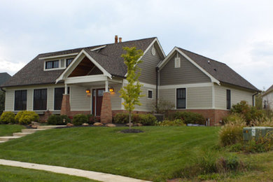 Imagen de fachada gris de tamaño medio de una planta con revestimientos combinados y tejado a dos aguas