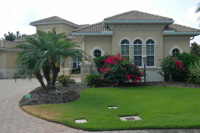 Example of a mid-sized beige one-story exterior home design in Tampa