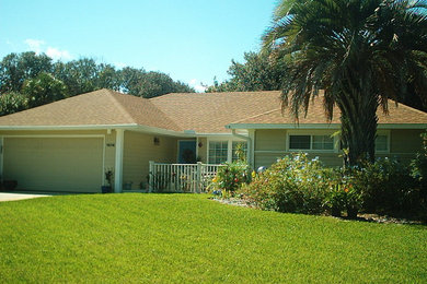 Example of a mid-sized classic beige one-story wood exterior home design in Jacksonville with a shingle roof