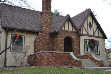 Imagen de fachada beige tradicional de tamaño medio de una planta con revestimiento de estuco y tejado a dos aguas