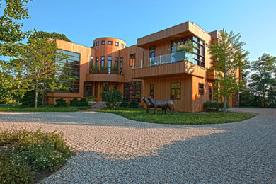 Foto de fachada de casa marrón actual extra grande de tres plantas con revestimiento de madera, tejado plano y tejado de metal