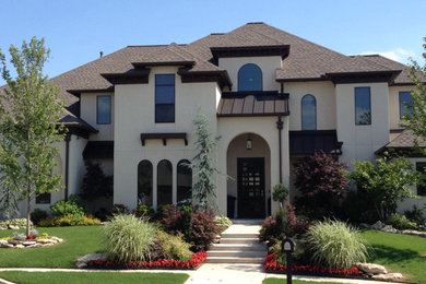 Example of a huge beige two-story stucco exterior home design in Other