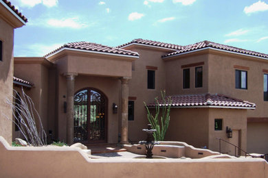 Large southwestern brown one-story adobe exterior home idea in Phoenix with a hip roof