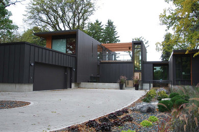 Ispirazione per la villa grande nera moderna a due piani con rivestimenti misti e tetto piano