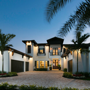 Inspiration for a large mediterranean white two-story stucco flat roof remodel in Miami