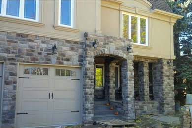 Inspiration for a mid-sized timeless brown two-story stone house exterior remodel in Other with a shingle roof