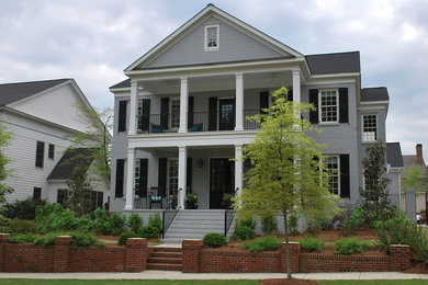 Imagen de fachada de casa gris clásica de tamaño medio de dos plantas con revestimiento de ladrillo, tejado a dos aguas y tejado de teja de madera