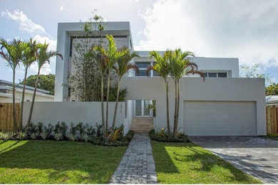 Example of a mid-sized trendy white two-story stucco exterior home design in Miami