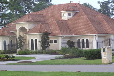 Mid-sized transitional beige one-story stone house exterior idea in Houston with a hip roof and a tile roof