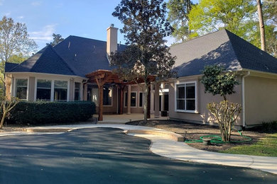 Example of a mid-sized transitional brown one-story stucco house exterior design in Houston with a hip roof and a shingle roof