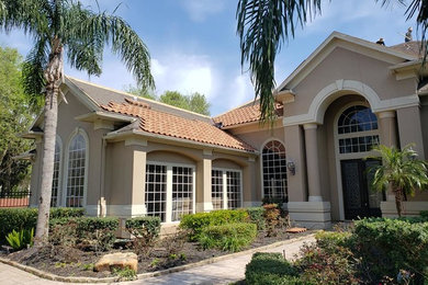 Example of a mid-sized transitional beige one-story stucco exterior home design in Houston with a tile roof