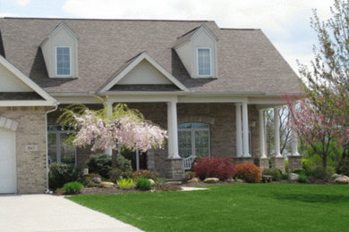 This is an example of a large and brown two floor brick house exterior in Other.