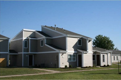 Example of a large gray two-story wood exterior home design in Other