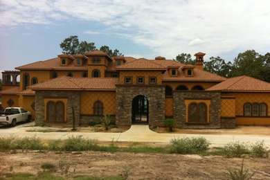 Large red three-story stone exterior home photo in Houston