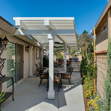 Outdoor dining area with patio cover, outdoor kitchen, and fans