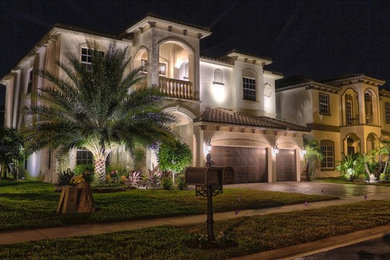 Huge mediterranean beige two-story mixed siding exterior home idea in Miami with a tile roof