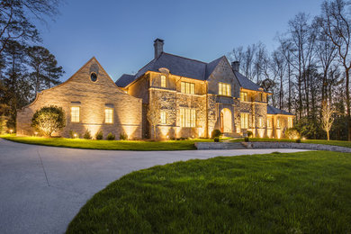 Inspiration for a huge timeless brown three-story stone exterior home remodel in Atlanta with a mixed material roof