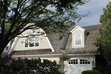 Foto de fachada de casa beige clásica grande de dos plantas con revestimiento de madera, tejado a doble faldón y tejado de teja de madera