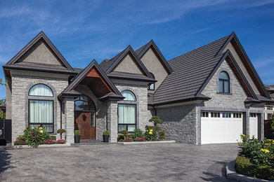 Inspiration for a large craftsman gray one-story stone gable roof remodel in Vancouver