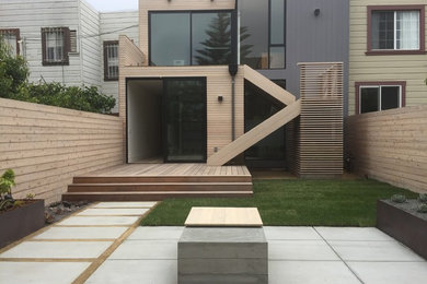Diseño de fachada de casa gris actual de tamaño medio de dos plantas con revestimiento de madera y tejado plano