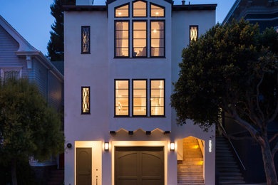 Ejemplo de fachada beige minimalista extra grande de tres plantas con revestimiento de estuco y tejado a dos aguas