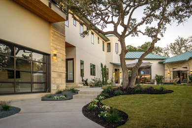 Example of a large minimalist beige two-story mixed siding exterior home design in Austin