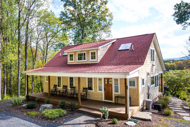 Imagen de fachada de casa beige clásica de tamaño medio de dos plantas con tejado a dos aguas, revestimiento de madera y tejado de teja de madera