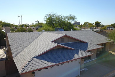 This is an example of a large traditional bungalow brick detached house in Phoenix with a hip roof and a shingle roof.