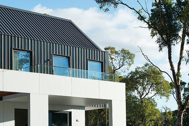 Diseño de fachada de casa blanca actual de tamaño medio de dos plantas con revestimiento de metal, tejado a dos aguas y tejado de metal