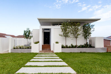 Diseño de fachada de casa blanca extra grande de tres plantas con revestimiento de aglomerado de cemento, tejado plano y tejado de metal
