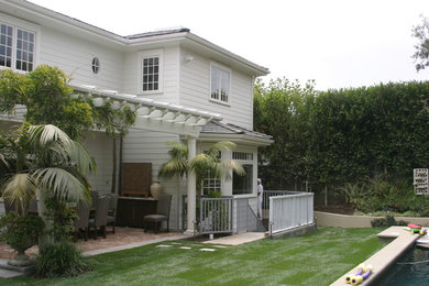 This is an example of a medium sized and white traditional two floor detached house in Los Angeles with concrete fibreboard cladding, a hip roof and a shingle roof.