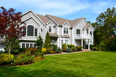 Imagen de fachada de casa gris clásica grande de dos plantas con revestimiento de madera, tejado a dos aguas y tejado de teja de madera