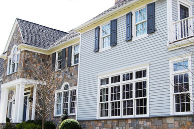 Example of a large classic multicolored two-story mixed siding exterior home design in New York with a shingle roof