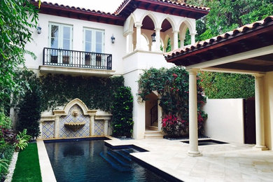 Inspiration for a large transitional white two-story adobe house exterior remodel in Miami with a tile roof