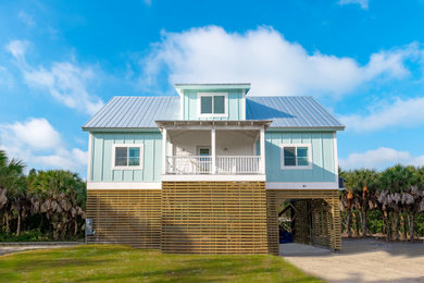 Modelo de fachada de casa azul marinera de tamaño medio de tres plantas con revestimientos combinados y tejado de metal