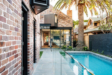 Mittelgroßes, Zweistöckiges Modernes Einfamilienhaus mit Backsteinfassade, bunter Fassadenfarbe, Satteldach und Blechdach in Sydney