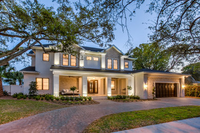 Large transitional white two-story stucco house exterior photo in Tampa with a shingle roof