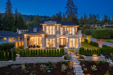 Inspiration for a large contemporary gray two-story stucco house exterior remodel in Vancouver with a shingle roof